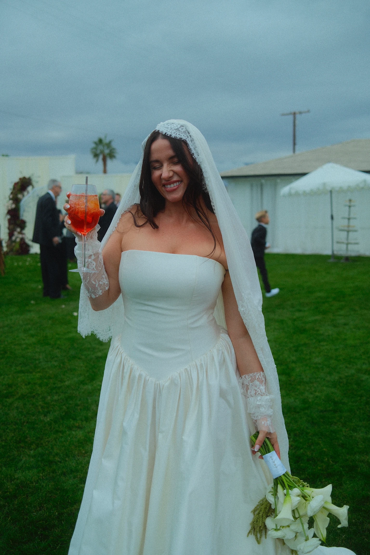 A bride smiling with a red signature cocktail.